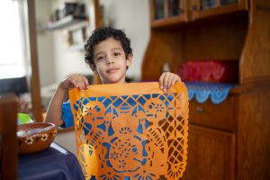 Child making Papel Picado at home